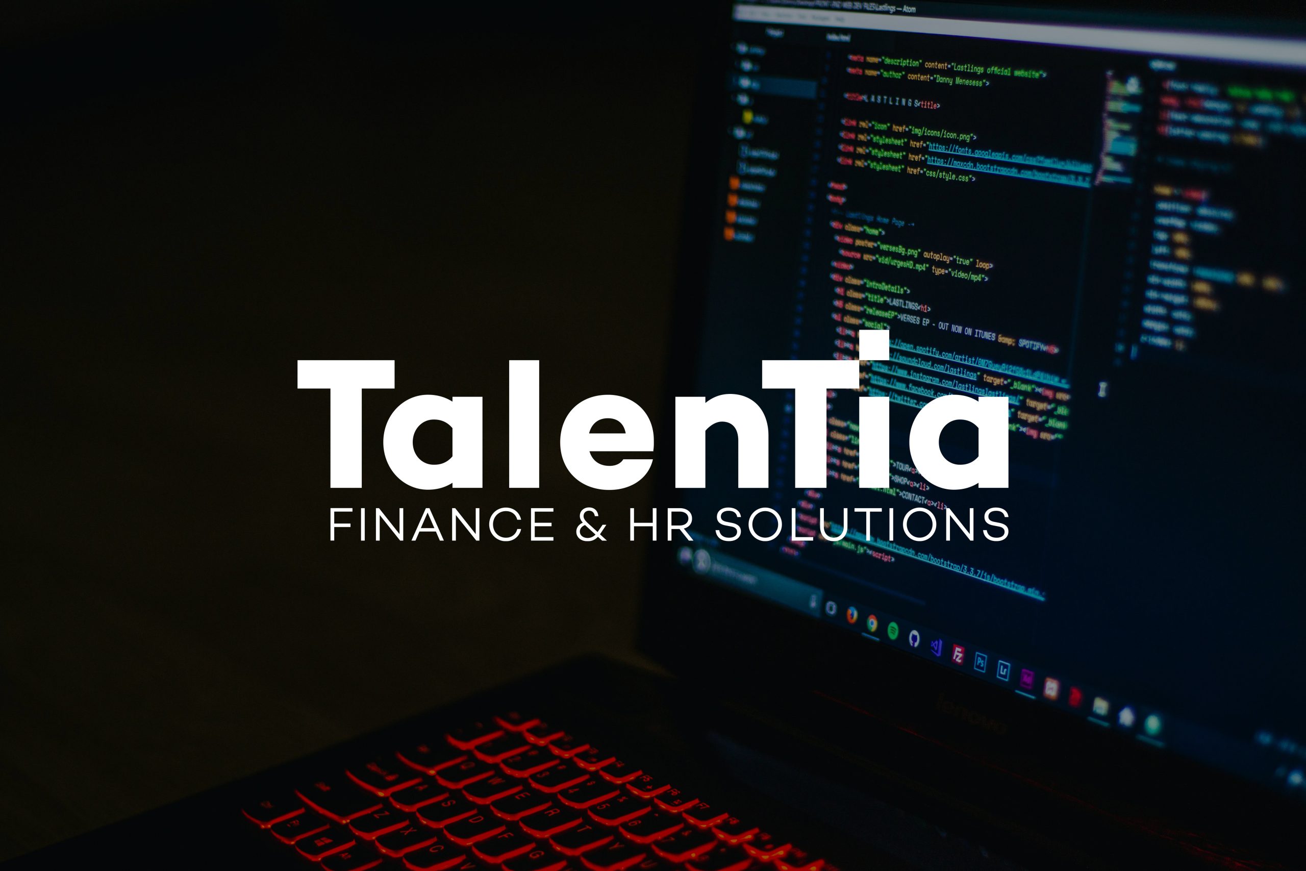 A laptop displaying source code data with the Talentia logo displayed on top