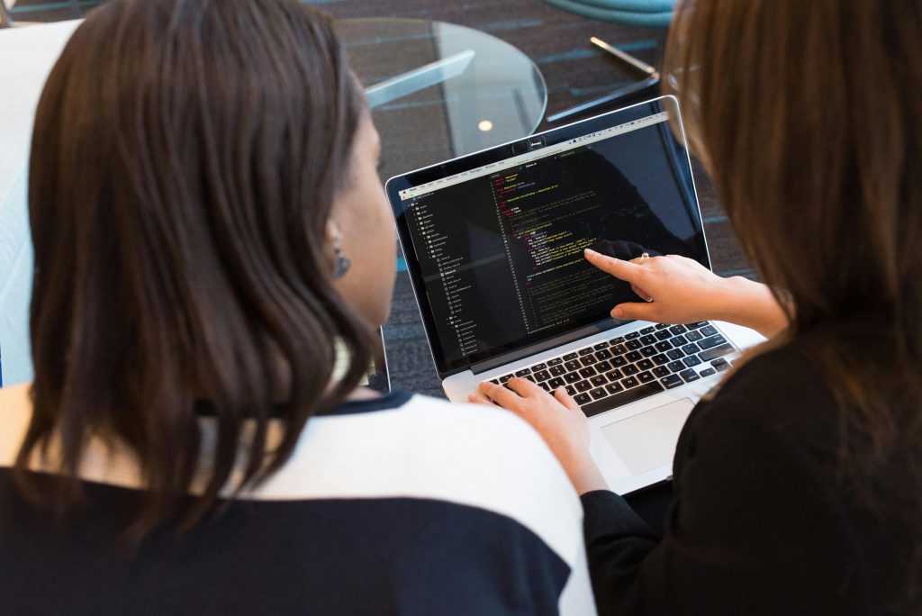 pexels-divinetechygirl-1181263 (2) Two colleges analysing code on a laptop